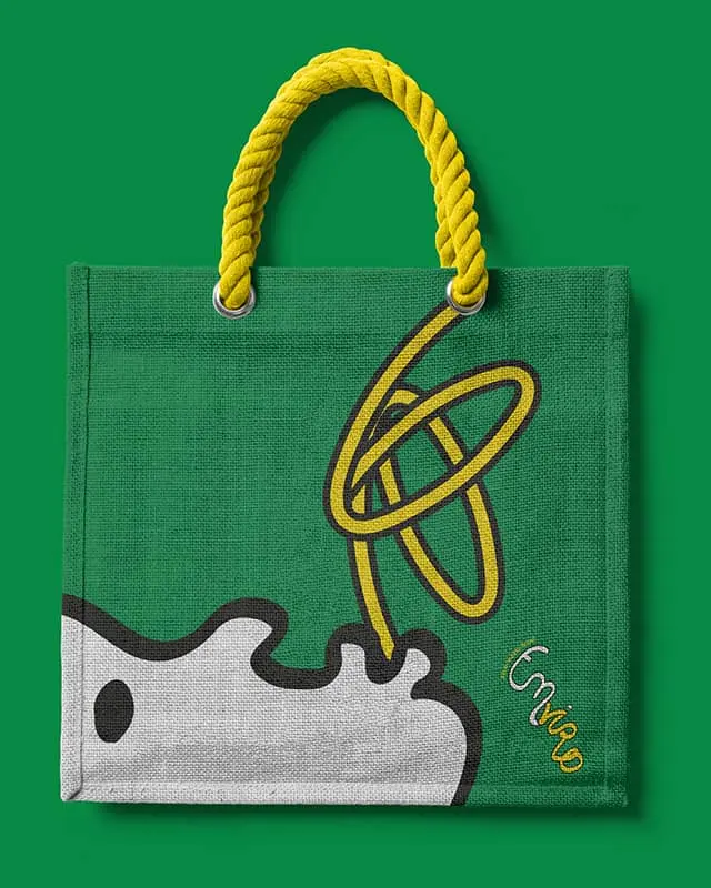 Sac en toile vert avec un visage blanc et une typographie jaune formant 'Enviro'.