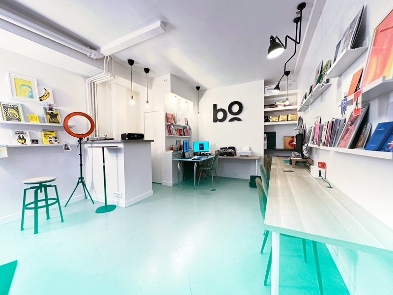 Salle principale de bo école avec des bureaux équipés d'ordinateurs Mac et une décoration design.
