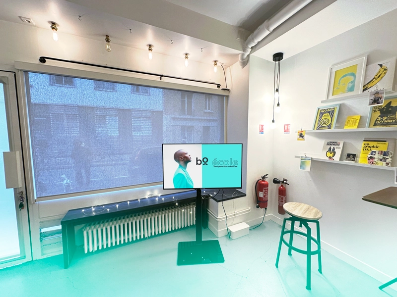 Salle avec un projecteur et des affiches graphiques dans les locaux de bo école.